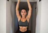 женщина подтягивается на турнике в дверном проеме